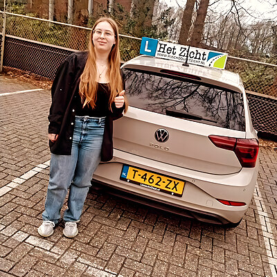 Geslaagde leerling bij de lesauto van Het Zicht