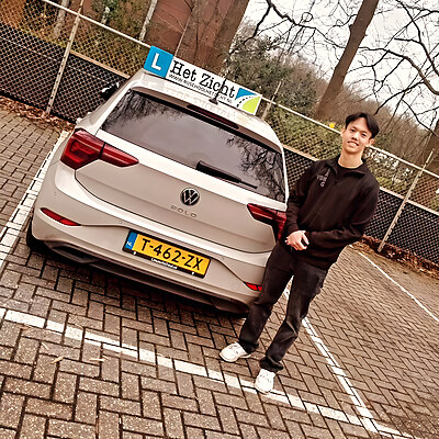 Geslaagde leerling achter de lesauto